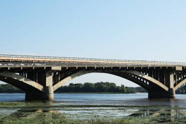 Güneşli bir günde nehrin üzerindeki kemer köprüsünün güzel manzarası