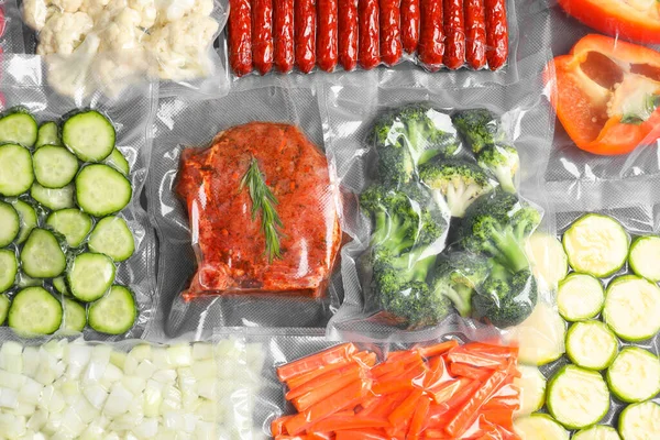 Many different food in vacuum packings on table, top view
