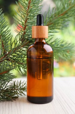 Çam yağı ve dallar beyaz ahşap masa üzerinde, yakın çekim