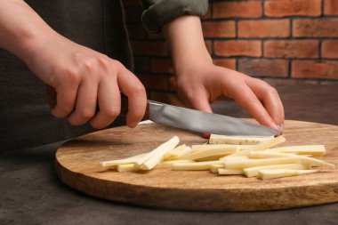 Siyah masada nefis taze olgun yaban havucu kesen kadın, yakın plan.