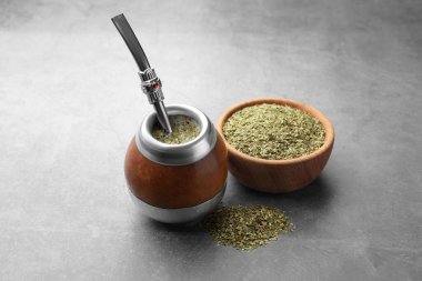 Bombilla soslu Calabash ve gri masada çay yaprakları.