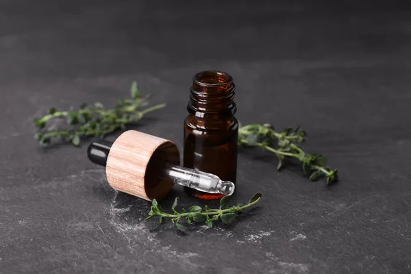 Natural thyme essential oil on black table