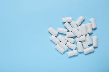 Açık mavi arka planda dişeti çiğneyen lezzetli, düz bir zemin. Metin için boşluk