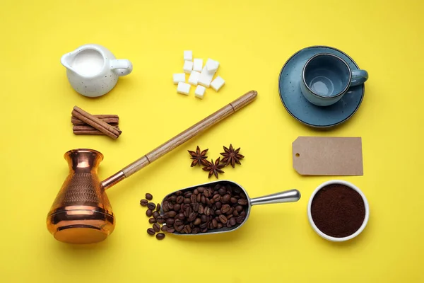Flat lay composition with turkish coffee pot and roasted beans on yellow background