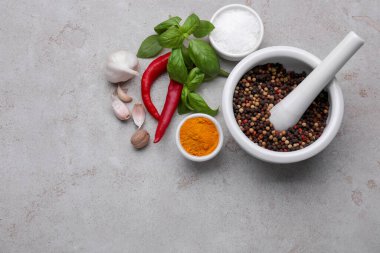 Açık gri masadaki topuzlu ve farklı baharatlı havan topu, düz yatıyordu. Metin için boşluk