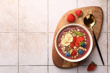 Taze böğürtlenli leziz meyve suyu kasesi, fayanslı yüzey üzerinde muz ve granola, düz yatak. Metin için boşluk