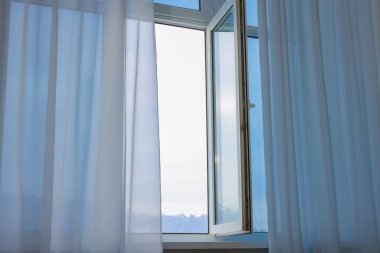 Açık pencere ve zarif beyaz perdeler. İç tasarım