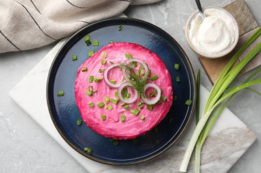 Kürk manto salatasının altında açık gri masada ringa balığı. Geleneksel Rus yemeği