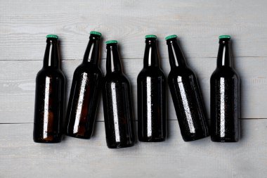 Gri ahşap zemin üzerinde cam bira şişeleri, düz yatıyordu.