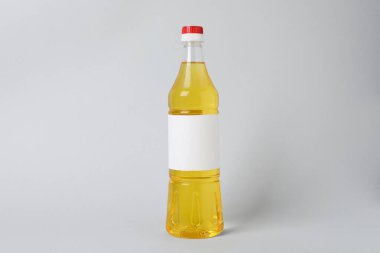 Açık gri arka planda bir şişe yemek yağı