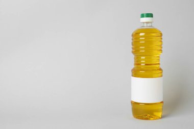 Açık gri arka planda bir şişe yemek yağı. Metin için boşluk