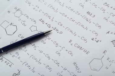 Farklı kimyasal formüllere ve kalemlere sahip bir sayfa kağıt, yakın plan.