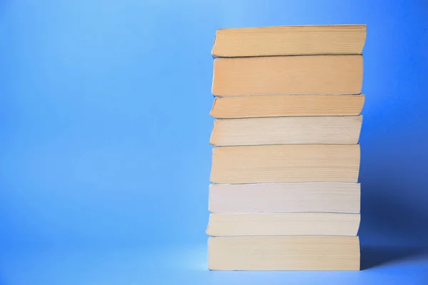 Collection of books on light blue background, space for text