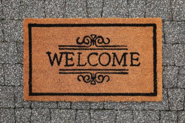 Kelimesi kelimesine kapı paspası. Kaldırıma hoş geldin, manzaralı.