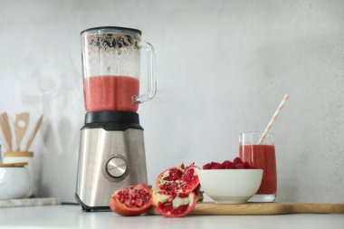 Blender ve smoothie malzemeleri mutfaktaki beyaz masada.