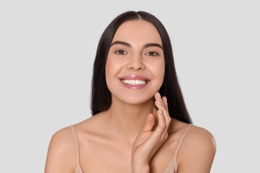 Açık gri arka planda çekici genç bir kadının portresi. Spa tedavisi