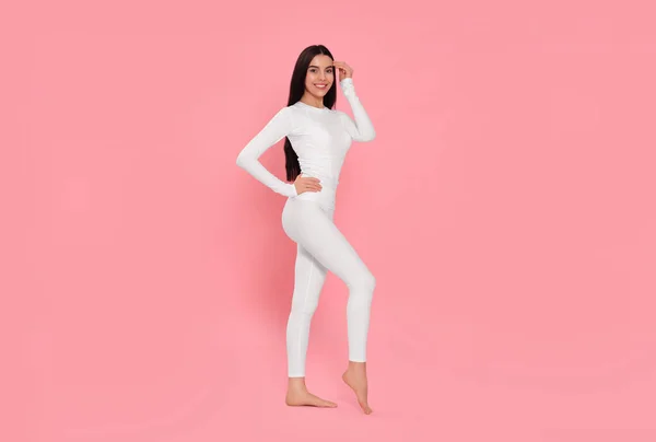 Woman in warm thermal underwear on pink background. Space for text