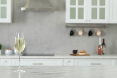 Mutfaktaki beyaz mermer masada bir bardak şarap. Metin için boşluk