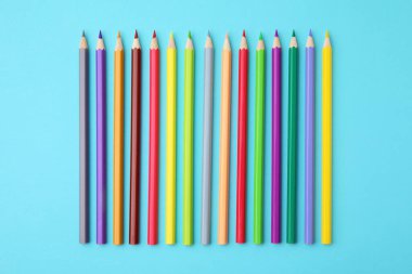 Açık mavi zemin üzerinde renkli ahşap kalemler, düz yatıyordu.