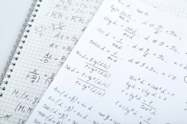 Masada farklı matematiksel formüllere sahip kağıtlar, yakın plan.