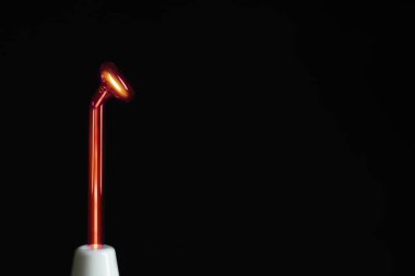 Siyah arka planda yüksek frekanslı Darsonval cihazı çalıştırıyorum. Yakın plan. Metin için boşluk