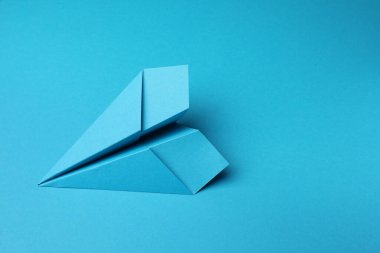 Açık mavi arkaplanda el yapımı kağıt uçak, metin için boşluk