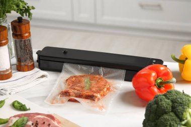 Süpürge ambalajı için mühür, beyaz mutfak masasında plastik torba içinde et.