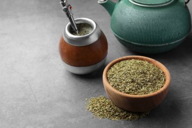 Bombilla soslu Calabash, çaydanlık ve çay yaprakları gri masada, mesaj için yer var.