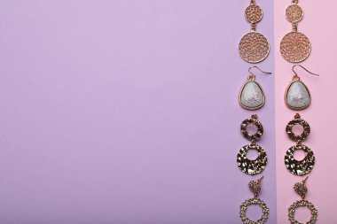 Different beautiful earrings on color background, flat lay. Space for text