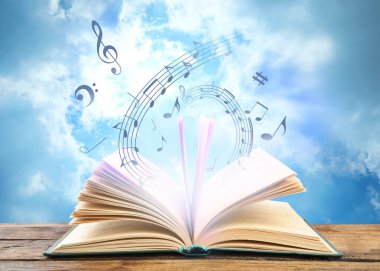 Kitaptan müzik akıyor. Gökyüzüne karşı ahşap masanın üzerinde uçan müzik sembolleri.