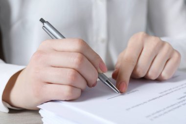 Ofisteki masada imza atan kadın, yakın plan.