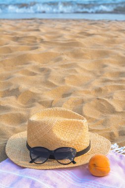 Güzel güneş gözlüklü şapka ve deniz kenarında şeftali.
