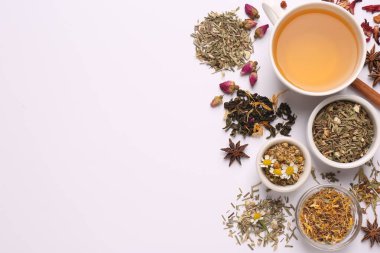 Beyaz arka planda taze demlenmiş çay ve kuru yapraklı kompozisyon, üst manzara. Metin için boşluk