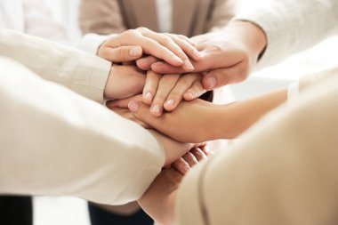 Group of people holding hands together indoors, closeup. Unity concept