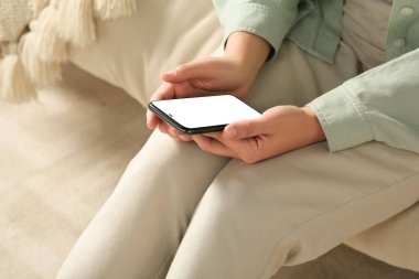 Yatakta akıllı telefon kullanan kadın, yakın plan.