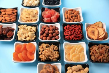 Kurumuş meyveler ve açık mavi arka planda fındıklar.