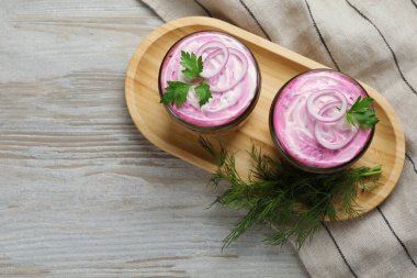 Tahta masadaki kürkün altında cam kavanozlar dolusu ringa balığı tepsisi, üst manzara ve yazı için yer. Geleneksel Rus salatası
