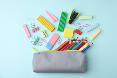 Açık mavi arka planda okul kırtasiyesi olan düz kompozisyon. Okula geri dön.