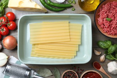 Gri ahşap masadaki lazanya için taze malzemeler.