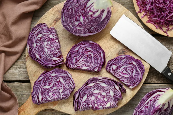 Tray with slices of fresh red cabbage on wooden table, flat lay