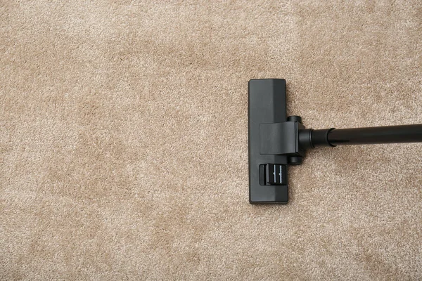 Removing dirt from carpet with vacuum cleaner indoors, top view. Space for text