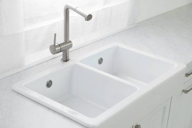 Modern lavabo ve musluk mutfağın penceresinin yanında. İç tasarım