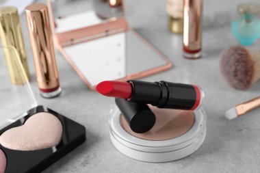 Açık gri masada güzel pembe ruj ve kozmetik ürünleri