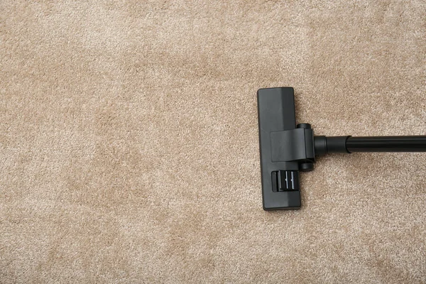 Removing dirt from carpet with vacuum cleaner indoors, top view. Space for text