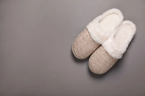 Pair of beautiful soft slippers on grey background, top view. Space for text