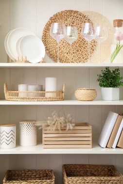 Bulaşık takımı ve farklı dekoratif eşyaları olan beyaz raf ünitesi.