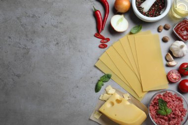 Gri masada taze lazanya malzemesi var, düz yerde. Metin için boşluk