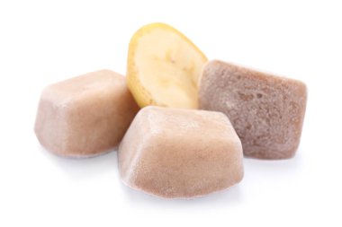 Donmuş muz püresi küpleri ve beyaz arka planda meyveler