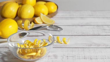 Kabuklu kase, taze limon ve beyaz ahşap masada zester. Metin için boşluk