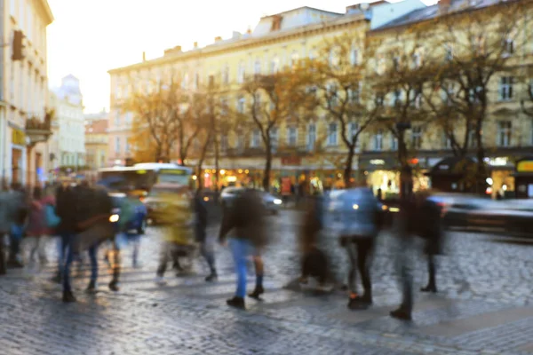 Blurred view of people crossing street in city